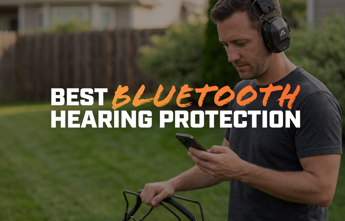 Man mowing the lawn in AXIL MX PRO earmuffs pausing to look at his phone